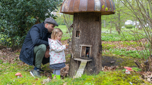 Child playing outdoors with her father